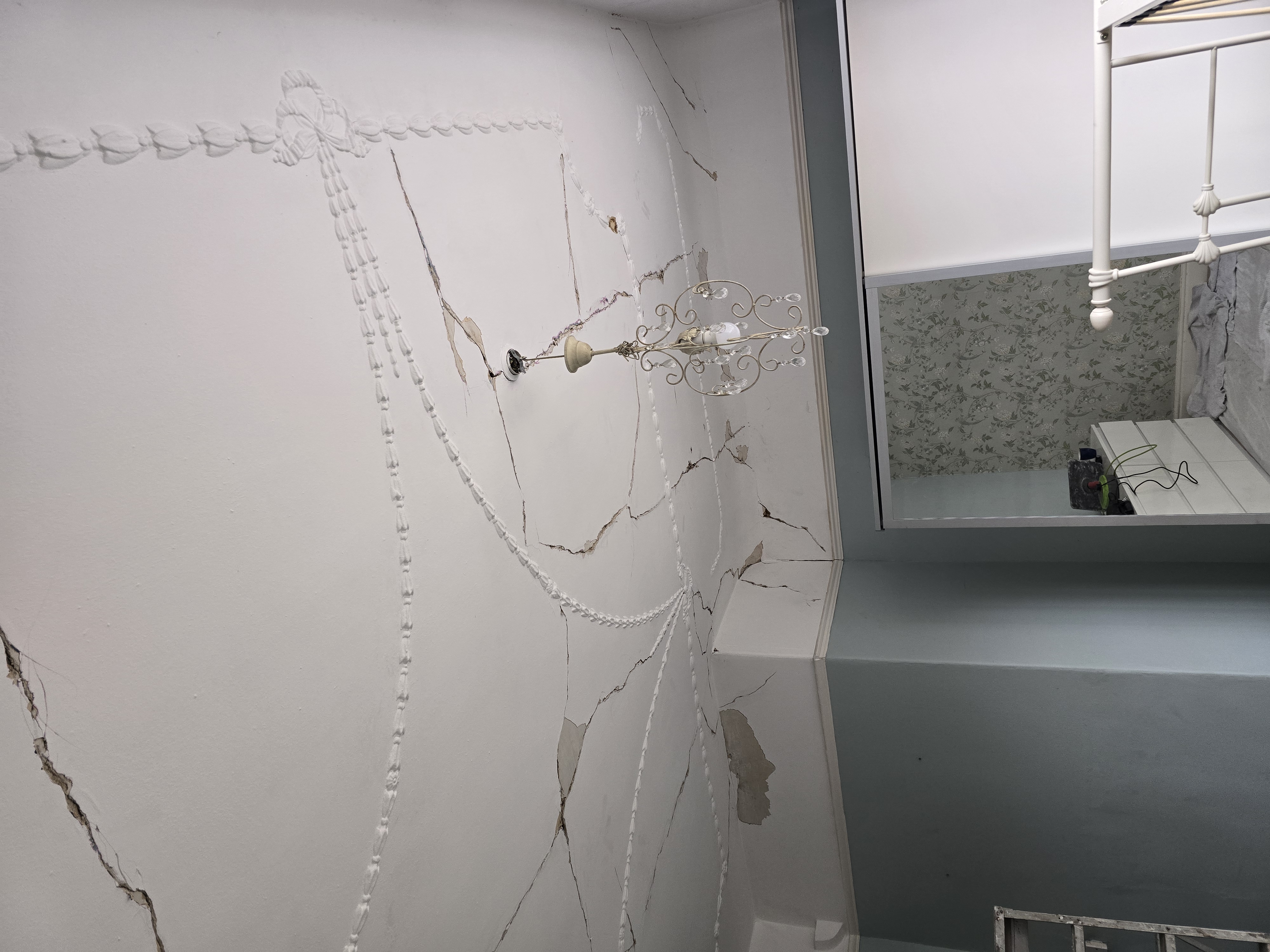 Before — cracked plaster wall with Edwardian swag mouldings